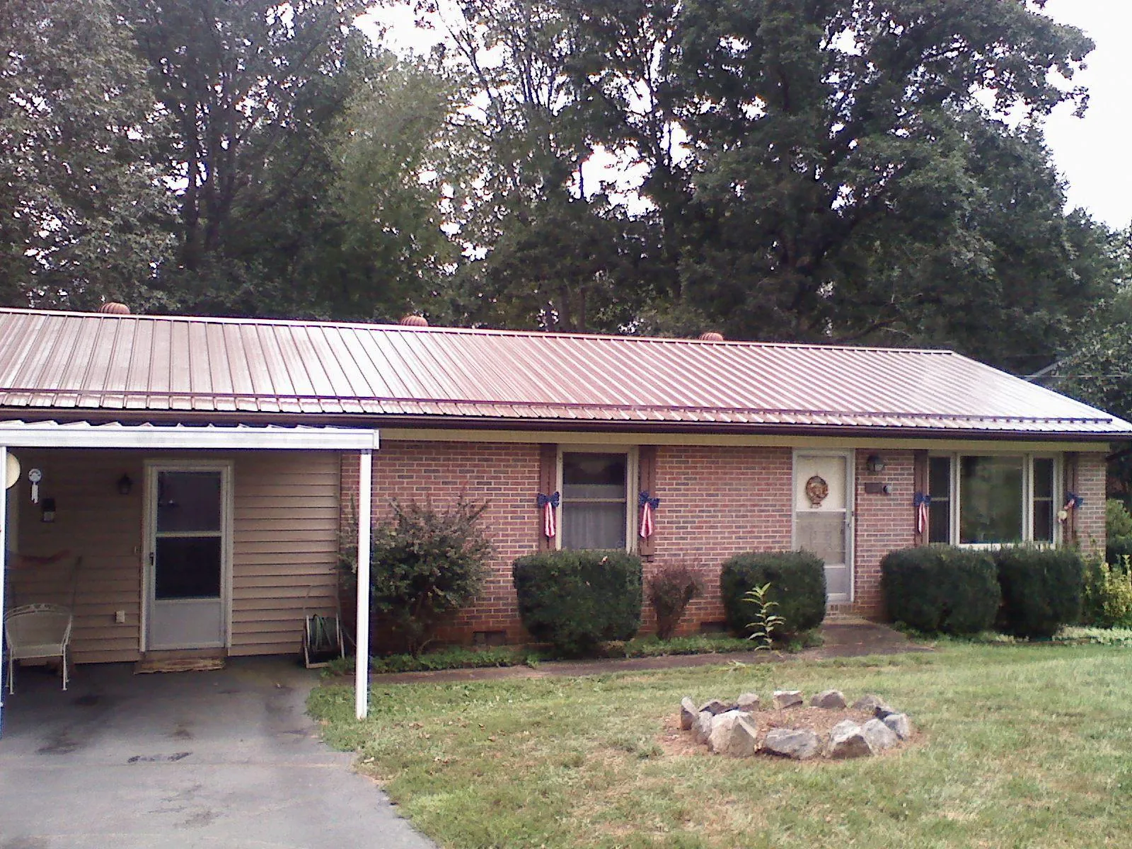 Bronze metal roof and carport on a brick ranch home — Roof Repair work by our crew in Belleville